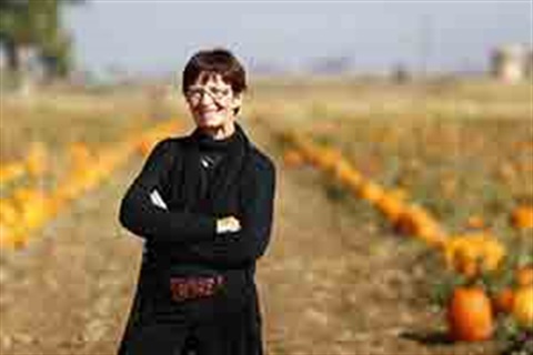 Kathy Rickart standing in a pumpkin patch