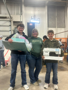 Lady and two boys with sewing machine and accessories